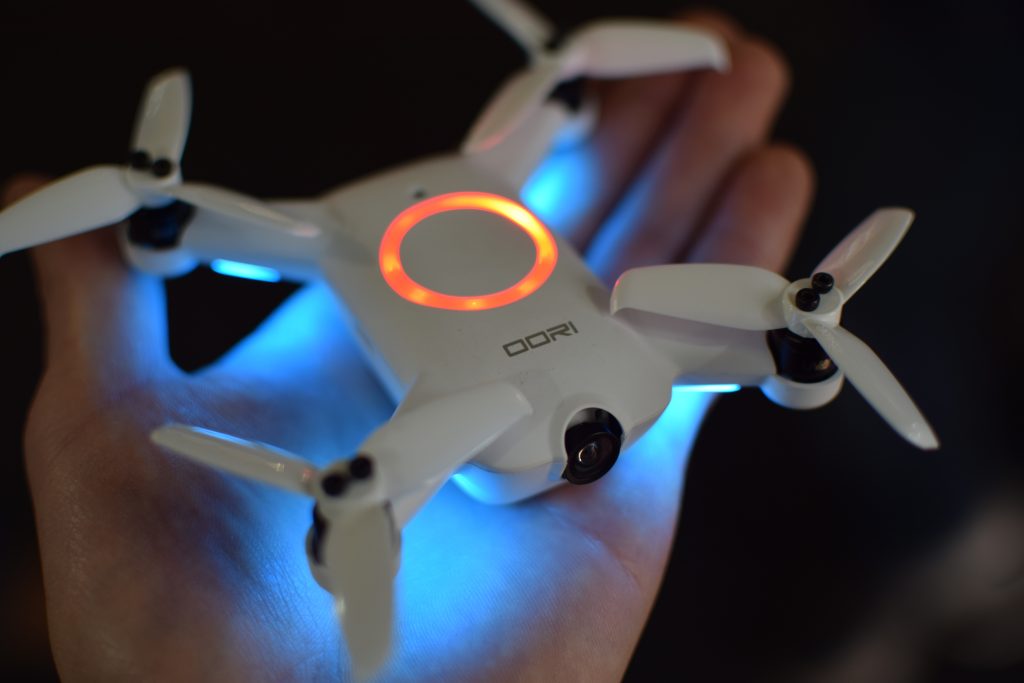 Drone, CES, Drone Rodeo. The oori drone, lit up with LED lights, sits in a pilot's hand.