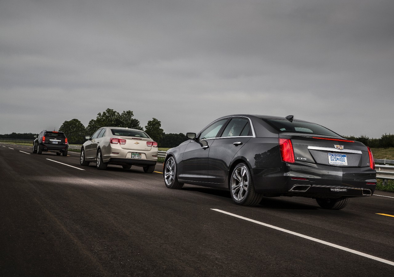 A 2015 Cadillac CTS, equipped with V2V technology, notifies the driver of a hard braking Cadillac SRX located two cars ahead.